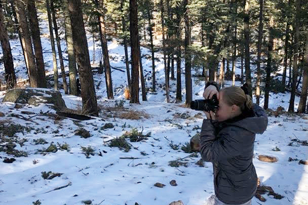 Person photographing in the snowy woods